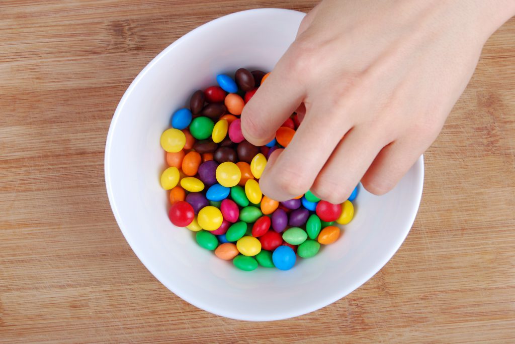 Hand in candy bowl