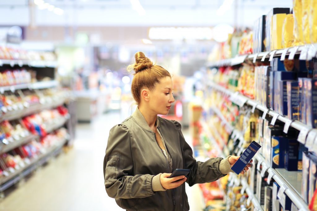 Woman looking at food package in supermarket