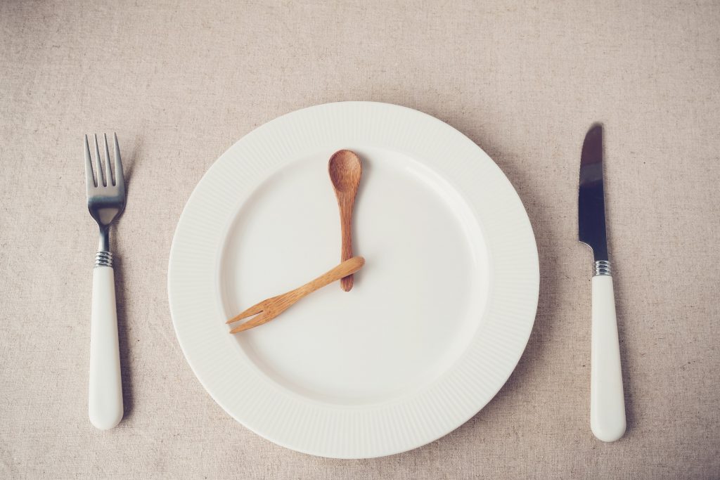 Image of plate with silverware forming clock hands