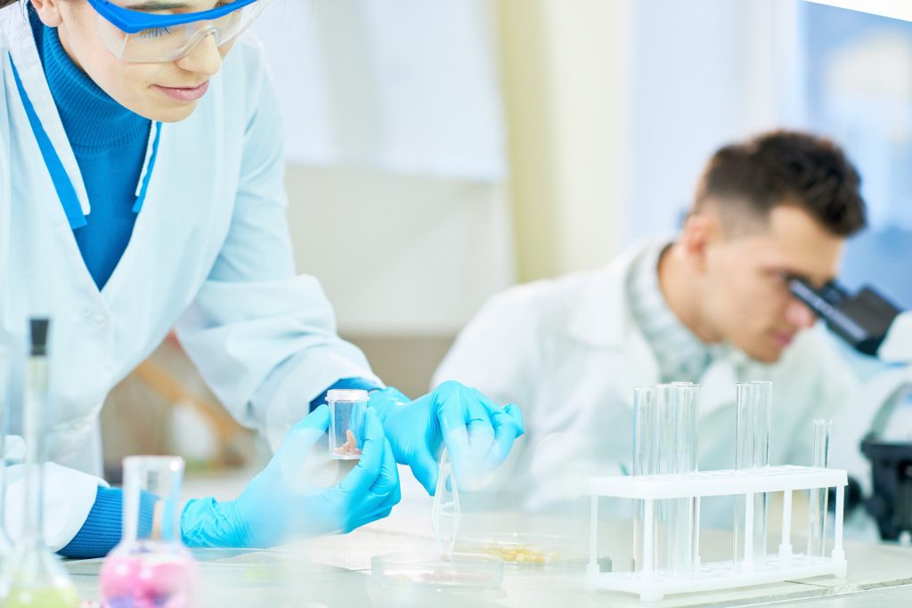 Woman putting food sample into test tube