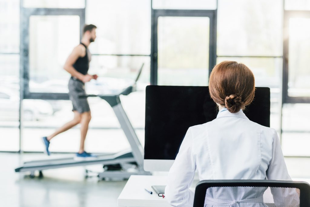 Researcher in front of computer measuring exercise performance of runner