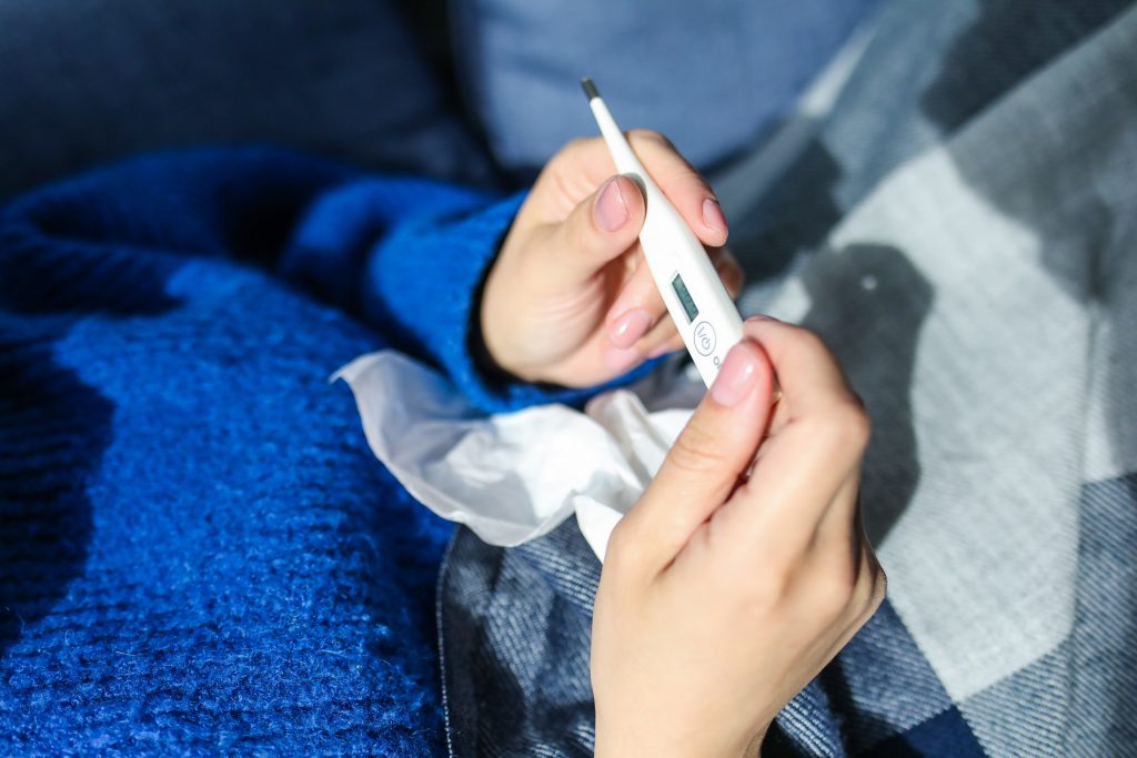 Person holding tissue and thermometer